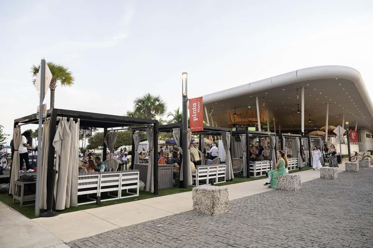 Bayshore Club outdoor cabanas and dining area with guests gathered near the waterfront.