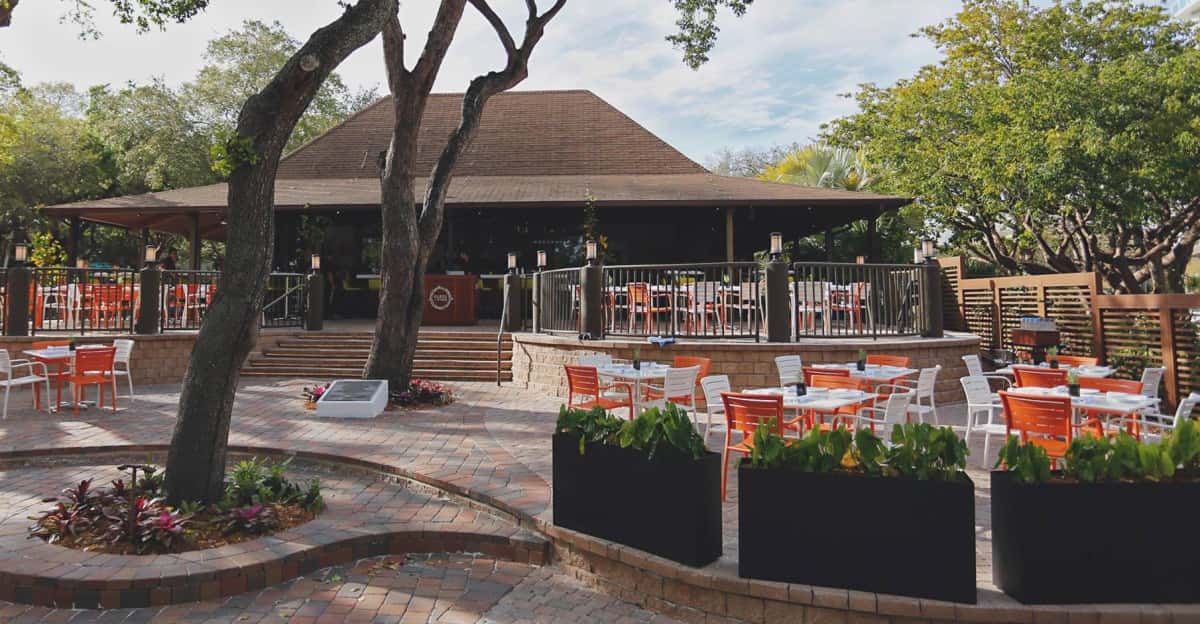 Exterior view of Glass & Vine restaurant located within Peacock Park showing outdoor dining area