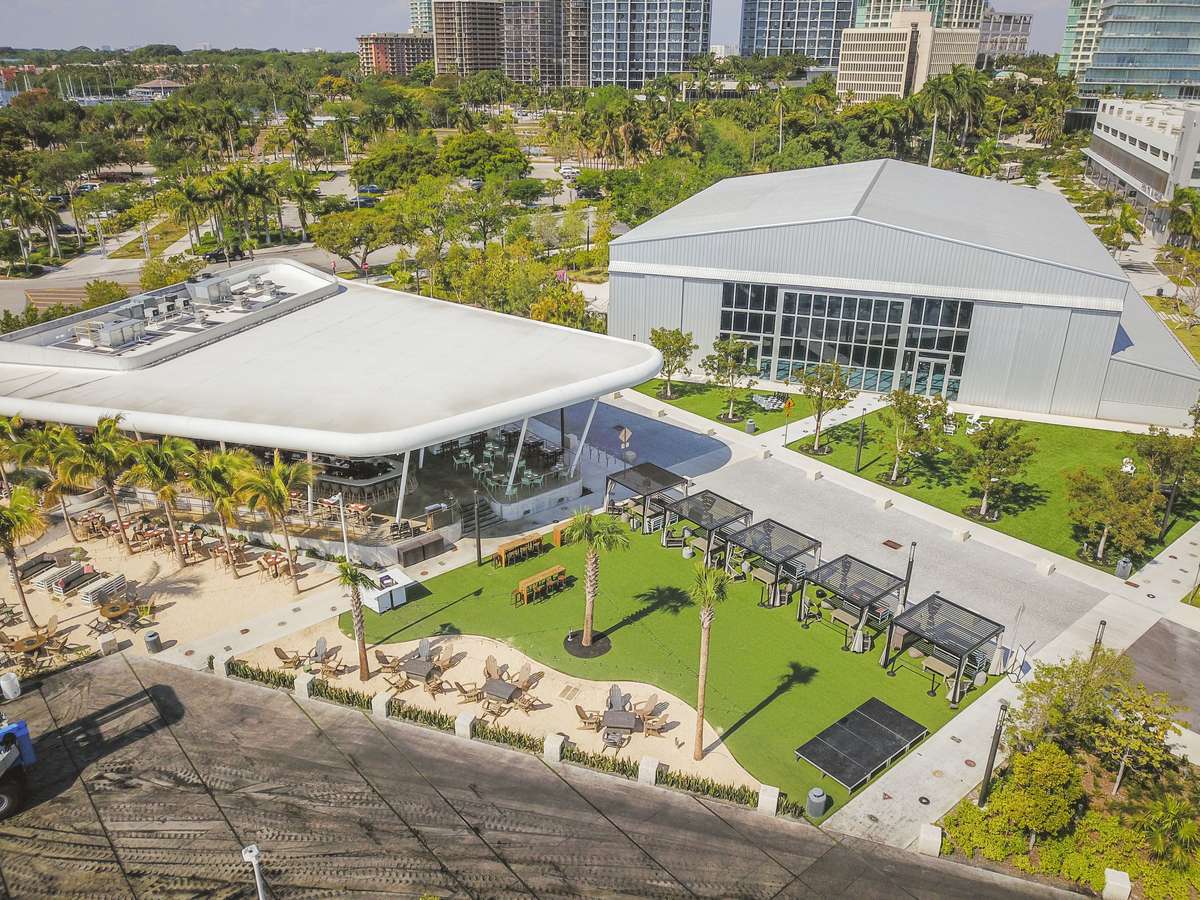 Aerial view of Bayshore Club with outdoor seating, cabanas, palm trees, and waterfront event space.