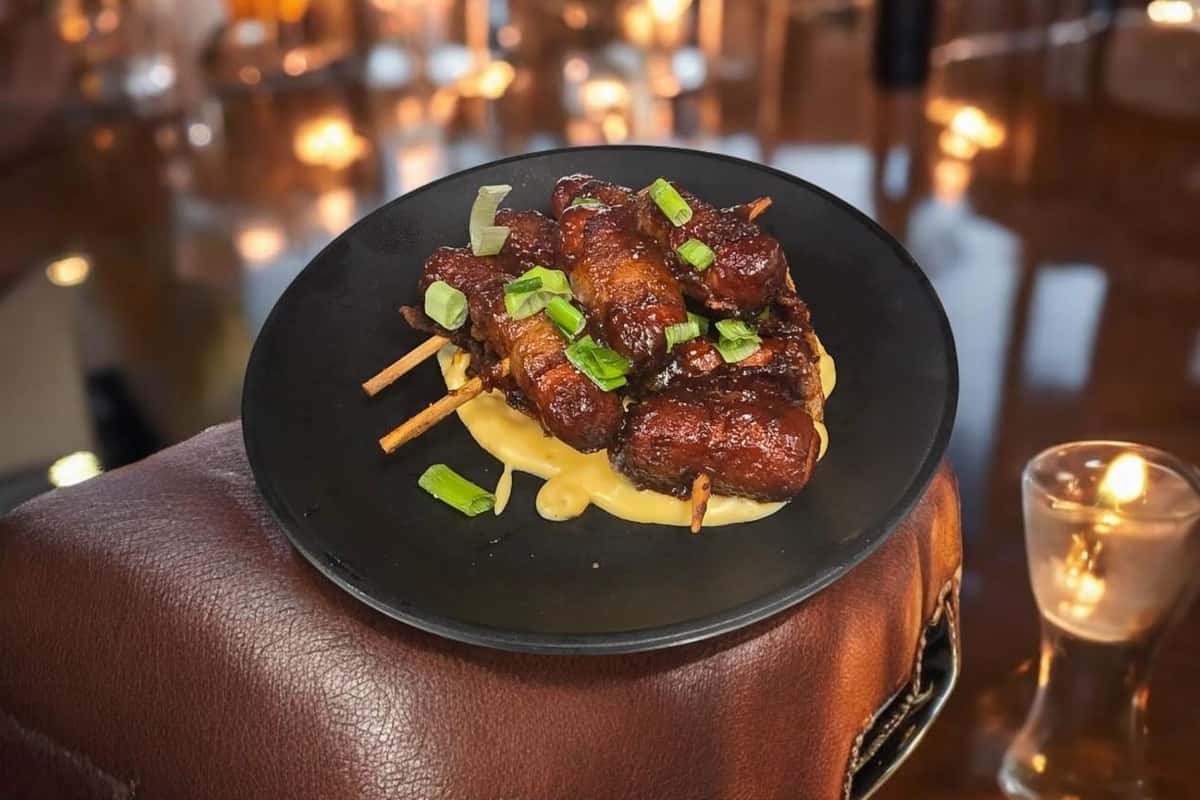 Grilled meat on skewers in a cheesy sauce