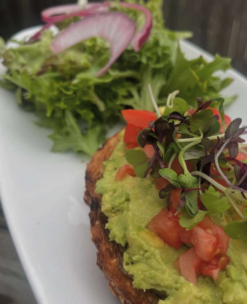 A crisp, golden base topped with fresh greens, creamy avocado, and vibrant diced tomatoes, finished with delicate microgreens for a light, refreshing, and flavorful bite.