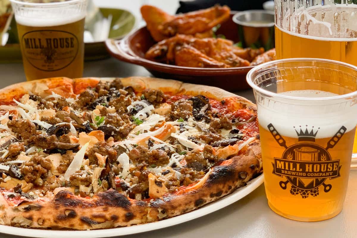 Pizza, wing,s and beer on a table