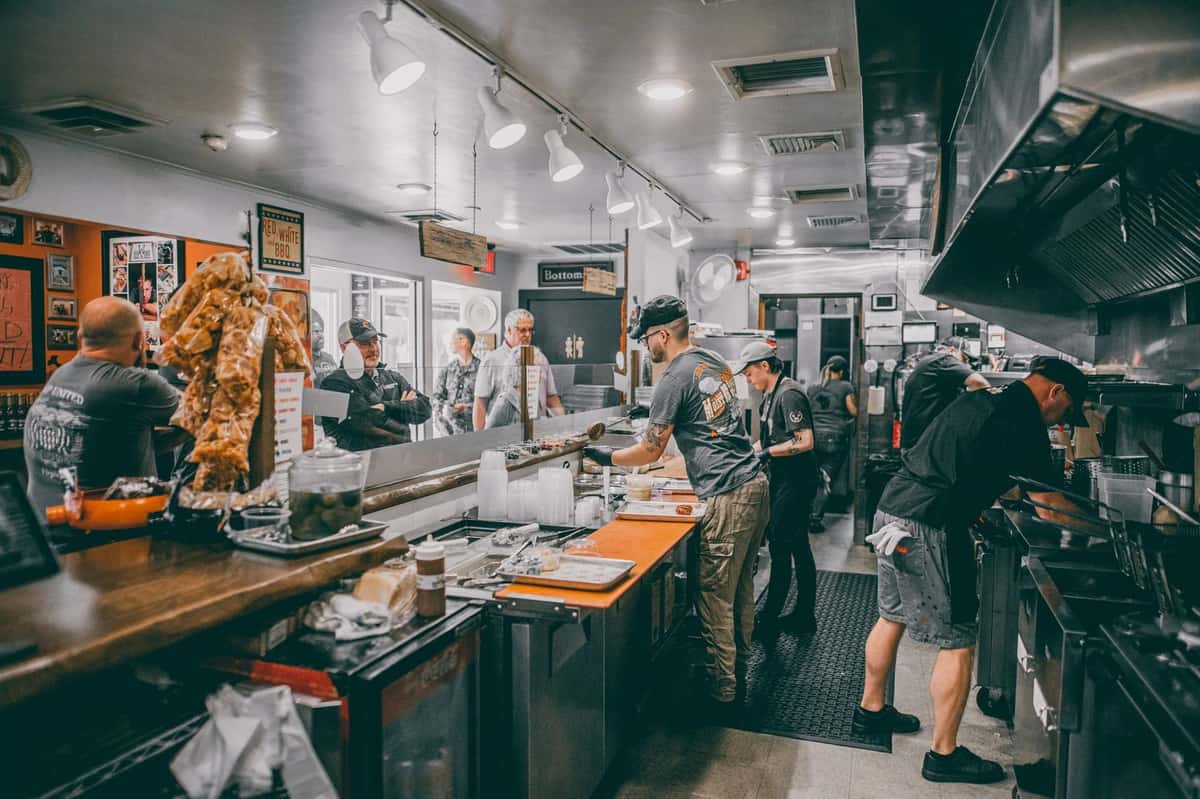 Interior view of staff working behind the counter serving customers in line