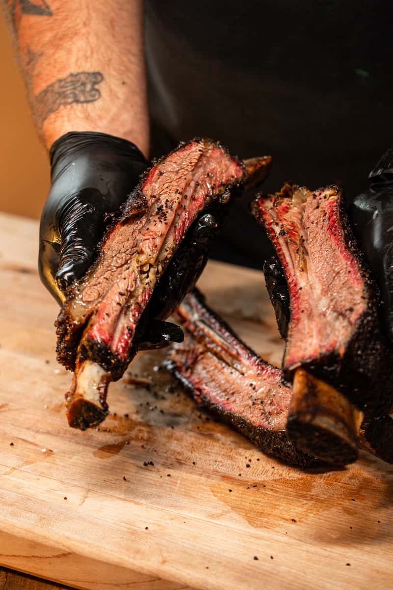Chefs hands holding big beef ribs