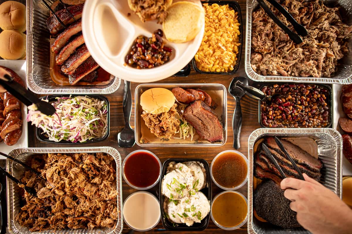 Trays of BBQ with sides and fixins on a table