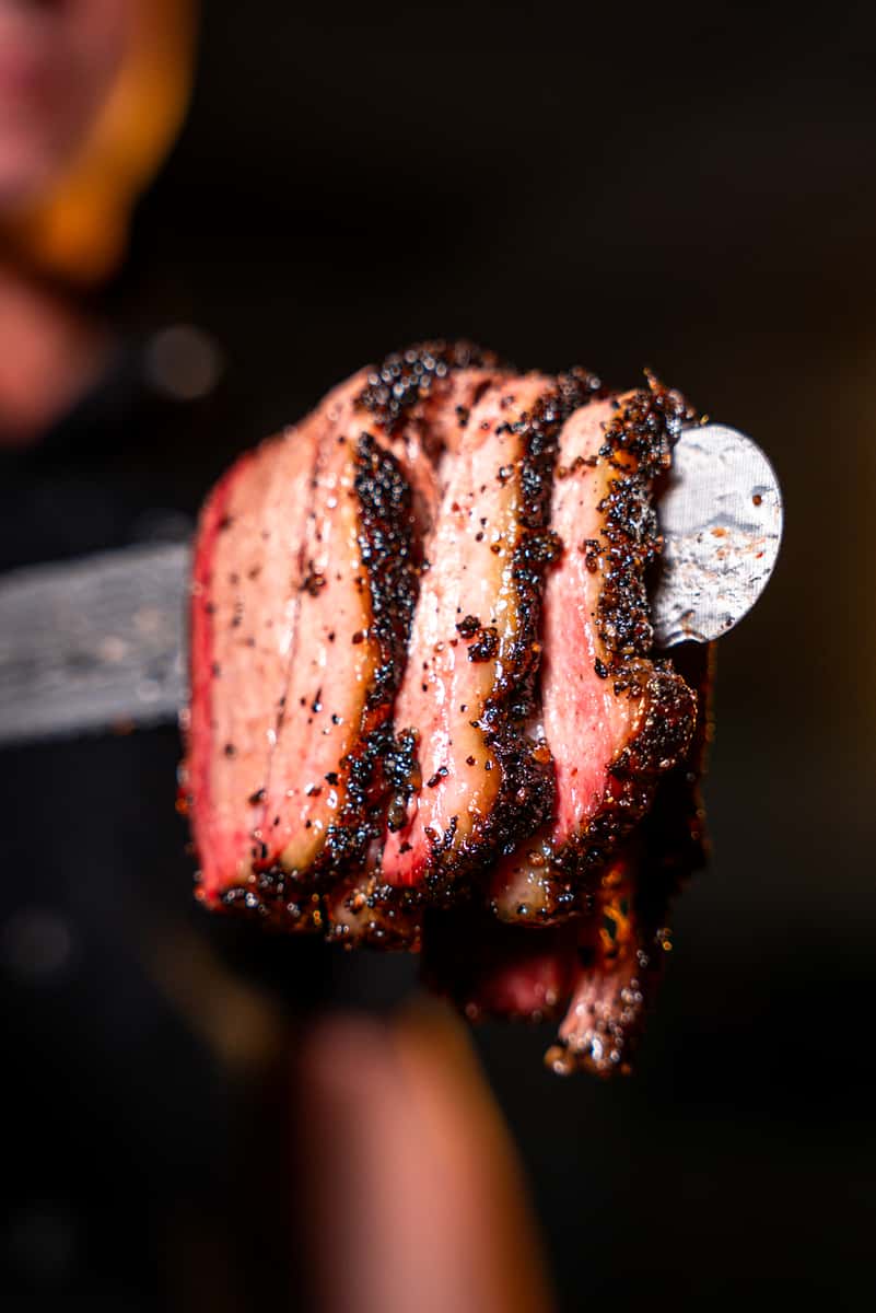 3 slices of moist brisket with beautiful smoke ring on a knife