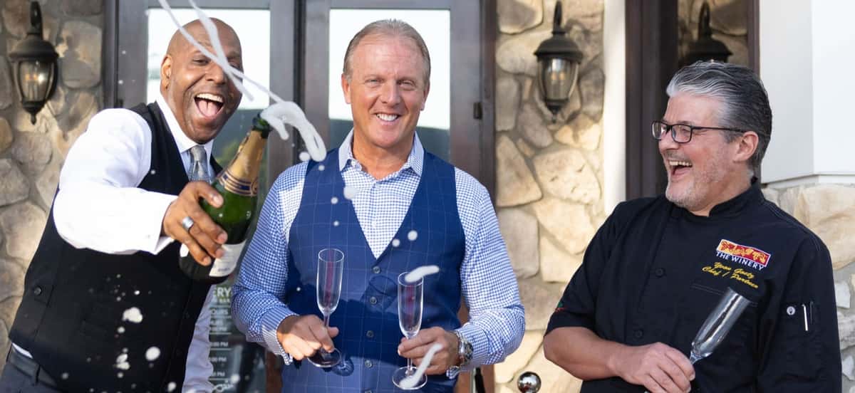 3 guys holding champagne glasses, and champagne flowing and having fun