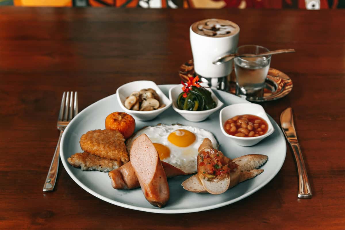 Breakfast plate including eggs, sausages, hash browns, beans and more