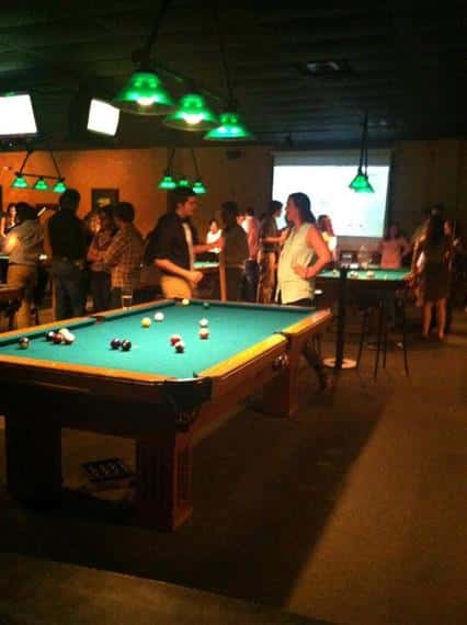 People standing around a billiard table 