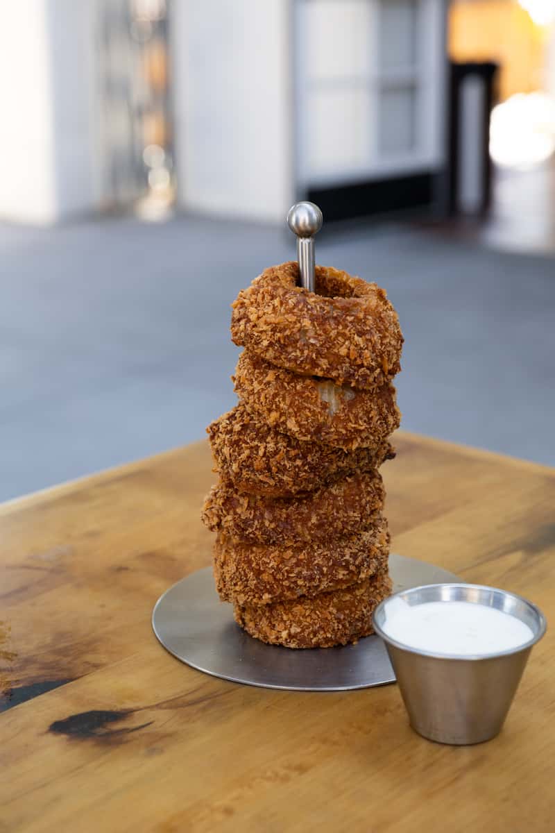 Crispy onion rings in a red fry container on Craiyon
