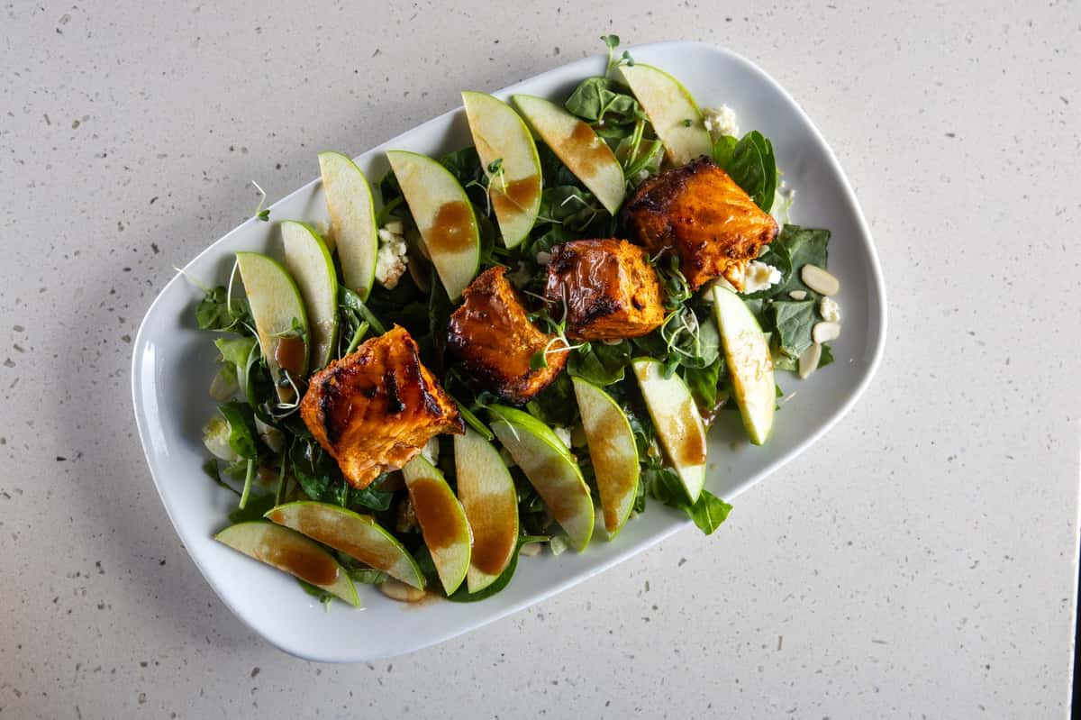 Platter of meat on a bed of greens