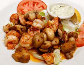 mushrooms and shrimp on a plate with a slice of tomato