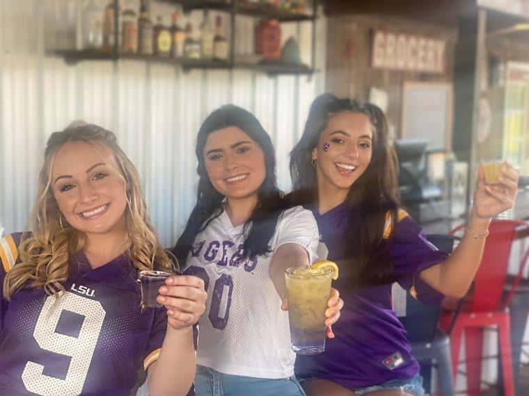bartenders smiling and holding cocktails