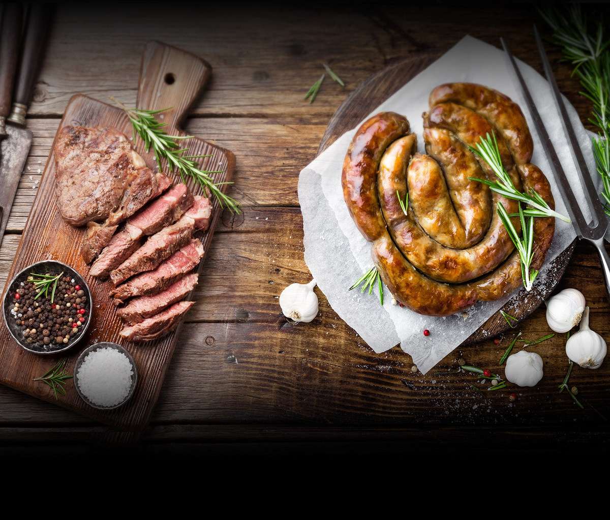sliced steak and sausage on cutting board