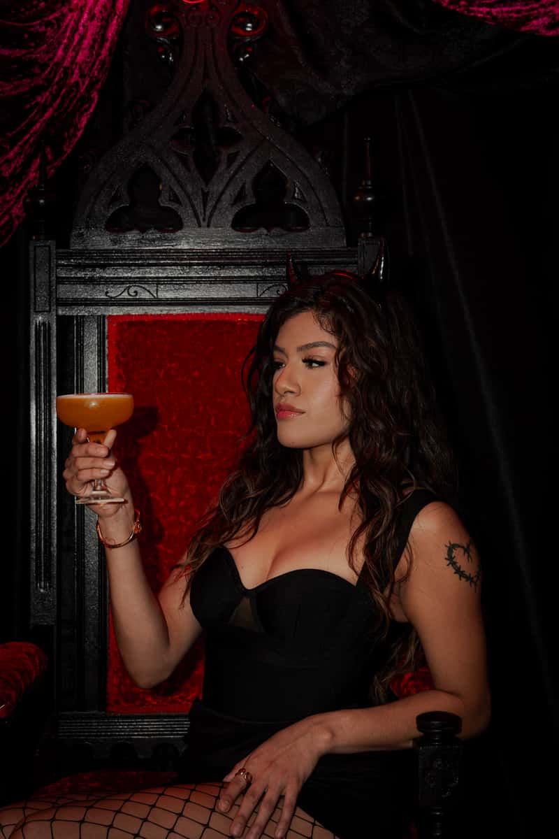 Woman enjoying a cocktail inside La Diabla