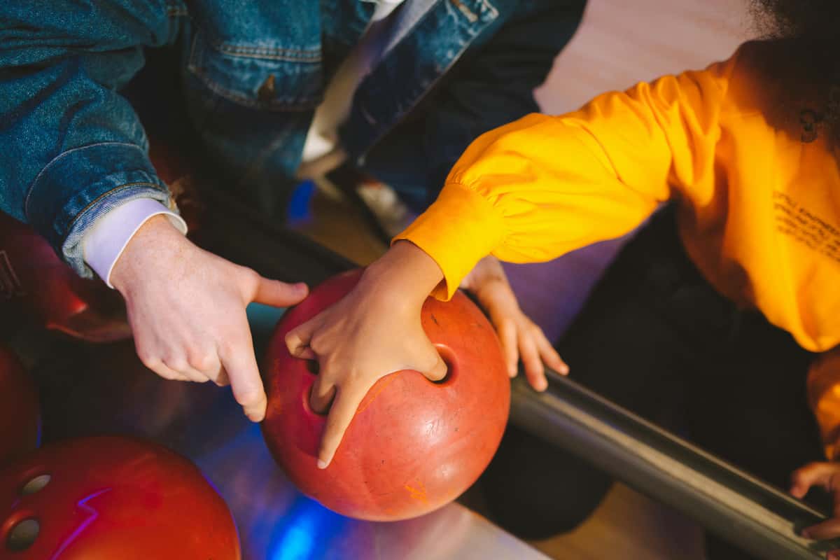 adult showing child how to bowl