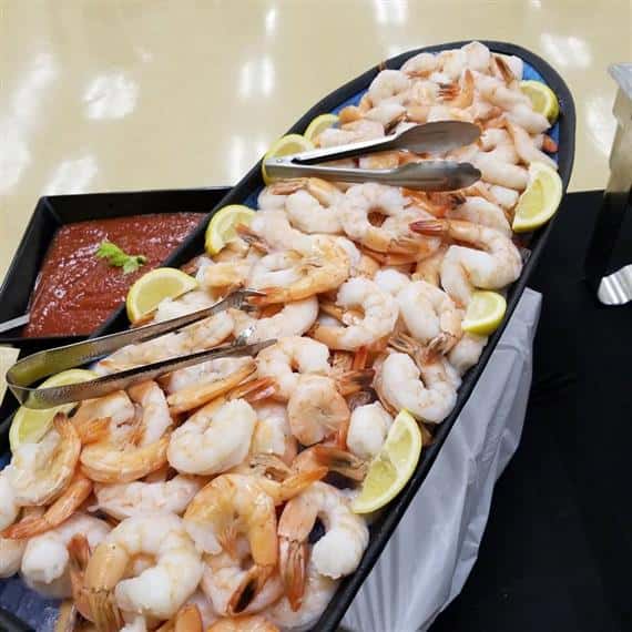 Tray with cooked shrimp, lemons and cocktail sauce