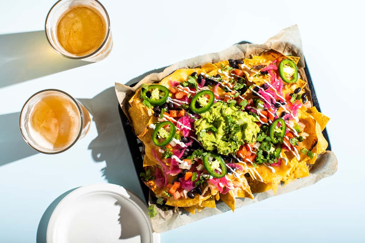 Tray of nachos with 2 glasses of beer