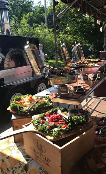 catering spreads on paddles on wood crates outdoors