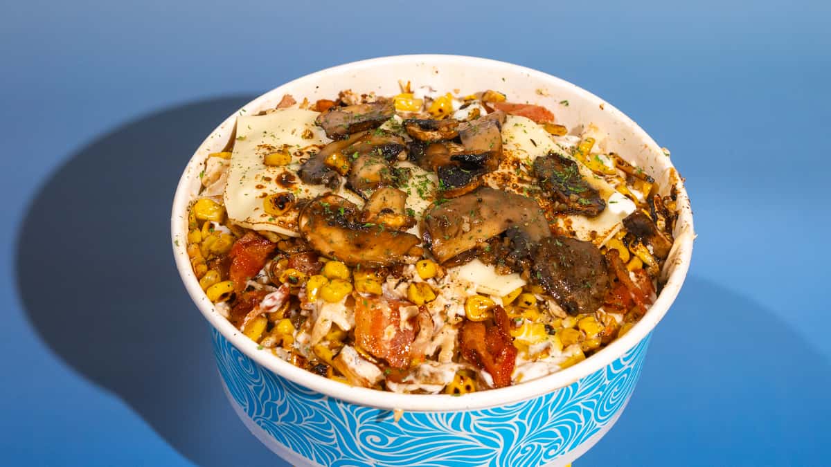 This "off-the-cobb corn" is insane: our roasted corn coated in "El Apto" sauce with shredded chicken, smoked bacon bits, grilled onions, cheese, and those garlic mushrooms! Este "maíz desgranado" está increíble: nuestro maíz asado cubierto con salsa "El Apto", pollo desmenuzado, trozos de tocinera ahumada, cebollas grille, queso y esos champiñones al ajillo!