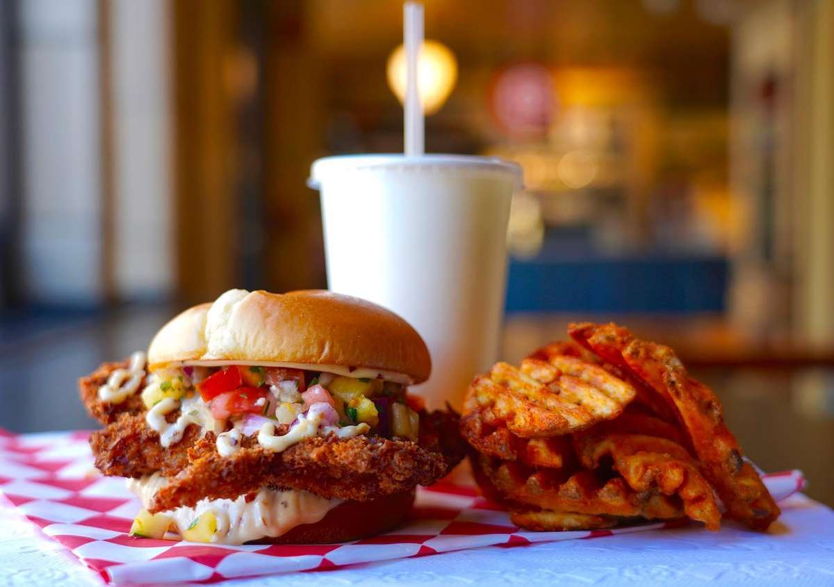 chicken sandwich and waffle fries with a drink