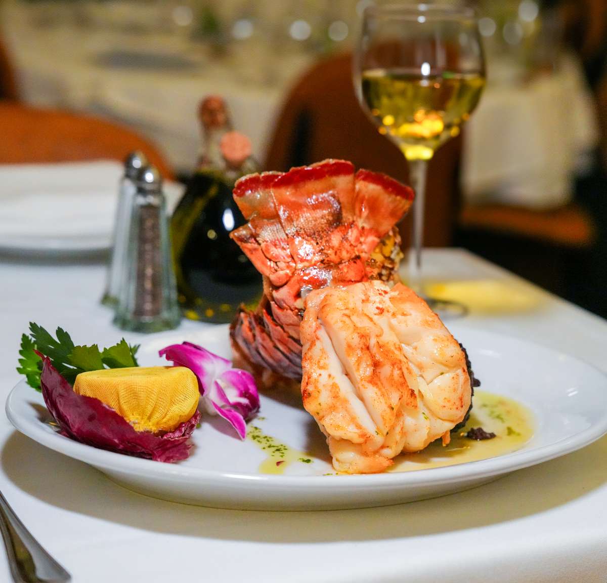 Surf and Turf on table set up, Lobster, Filet Mignon, White Wine at Empire Hawaii