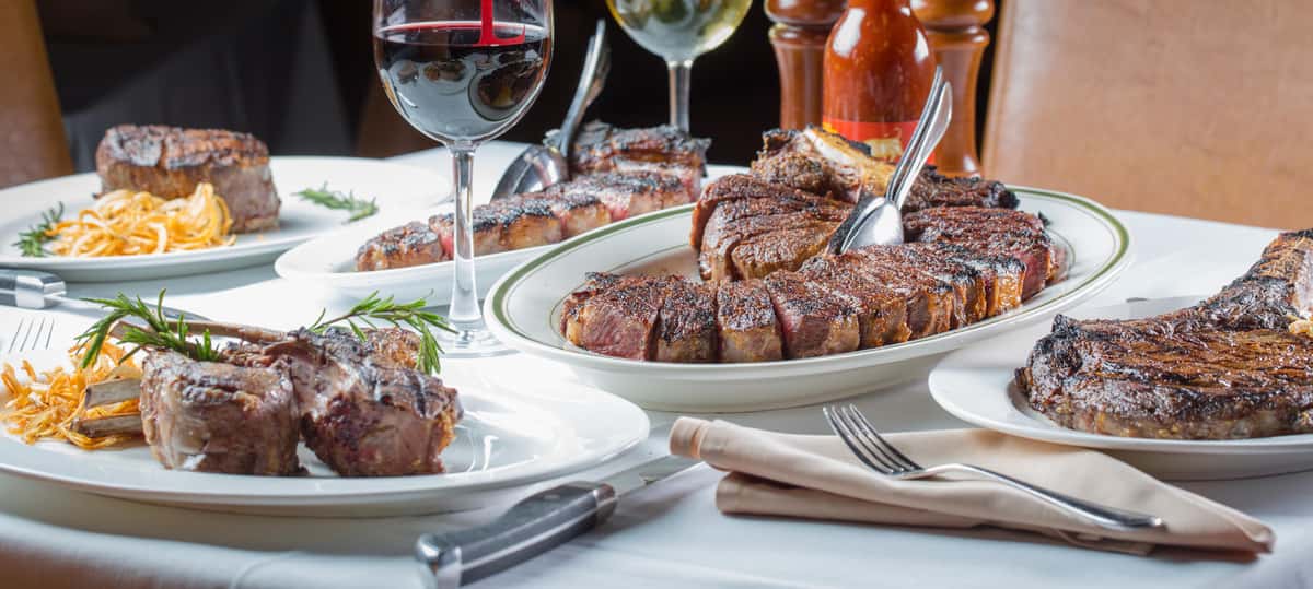 Empire Hawaii dinner table with steaks and wine