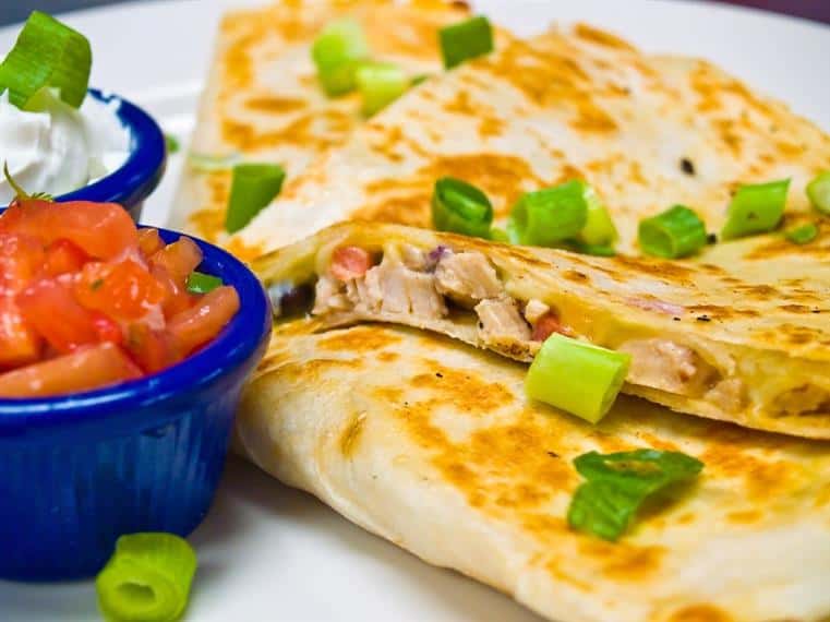 Chicken quesadilla with chives, side of sour cream and salsa