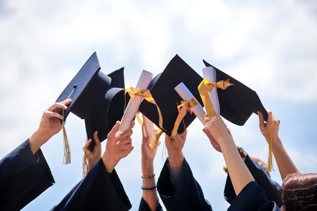 Graduates holding up their caps in the air