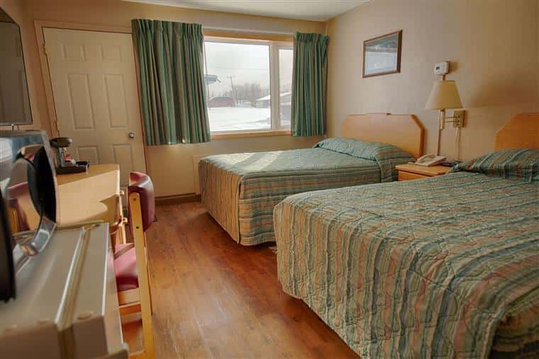 a hotel room with two queen beds and a large window