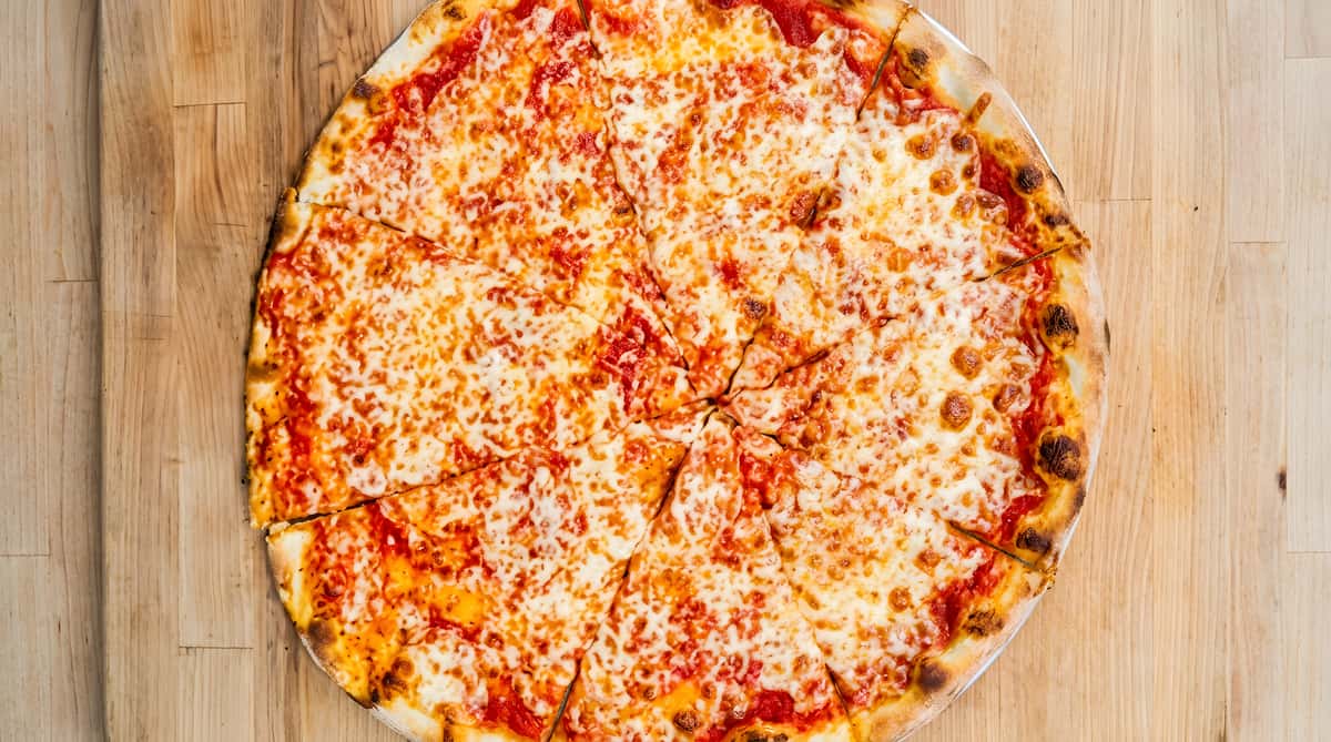 Cheese pizza with red sauce and melted mozzarella on a wooden surface.