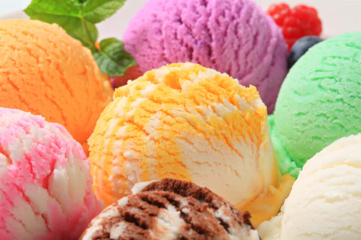 Colorful scoops of assorted ice cream flavors including orange, pink, purple, green, chocolate, and vanilla.