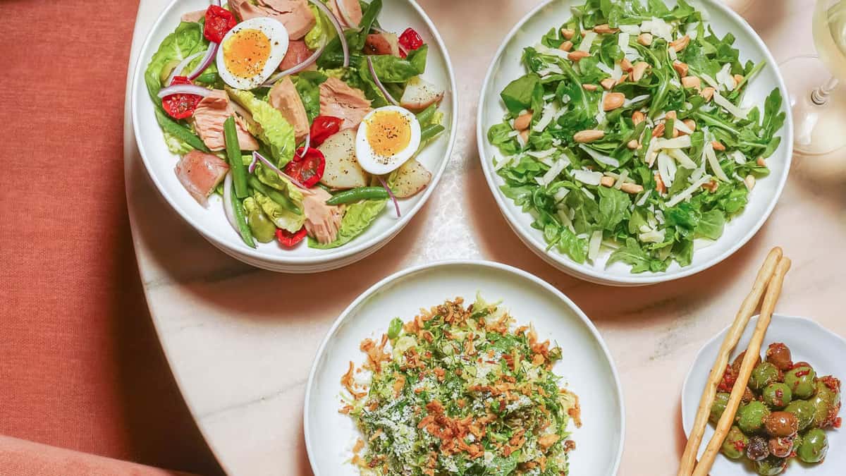 Three plates of salad on a table