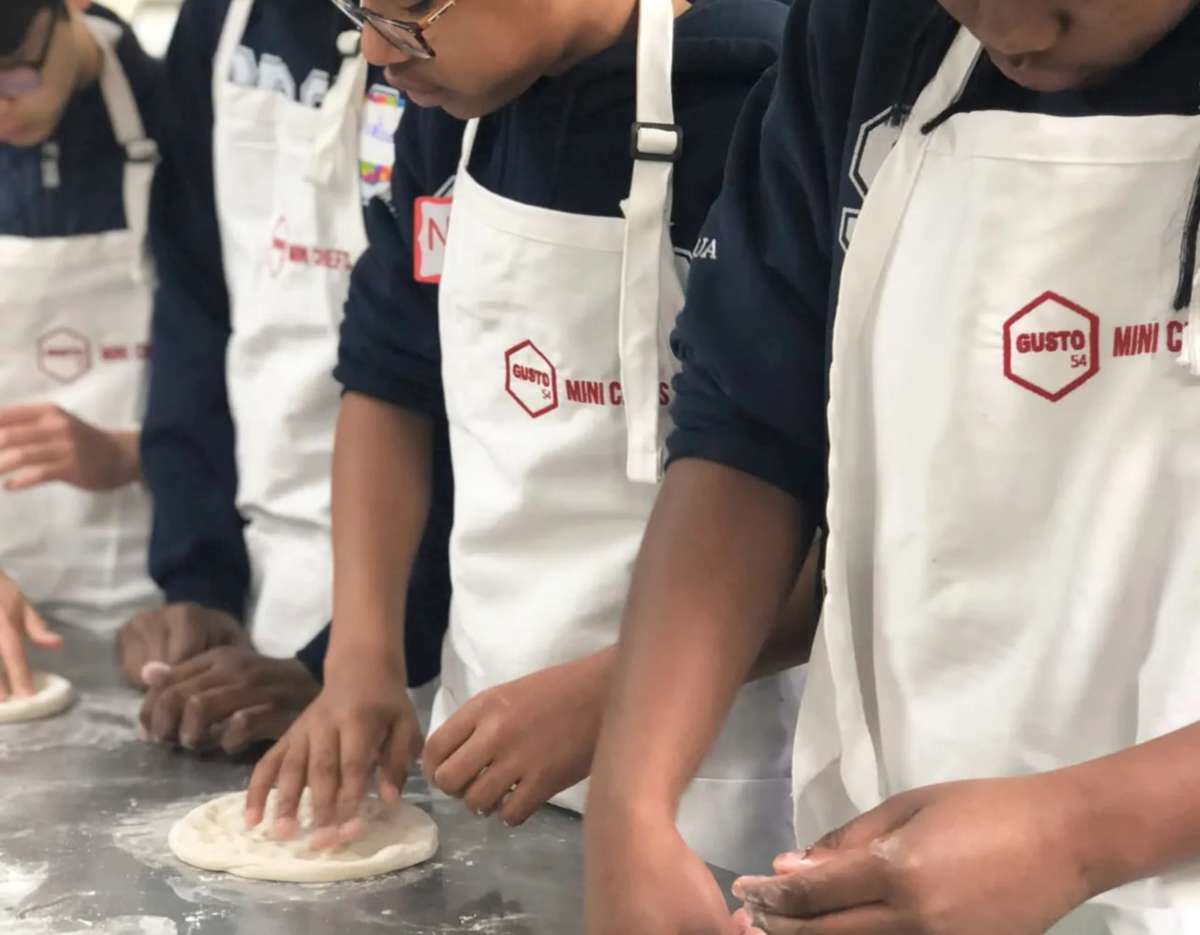 Gusto 54 Mini Chefs wearing branded aprons