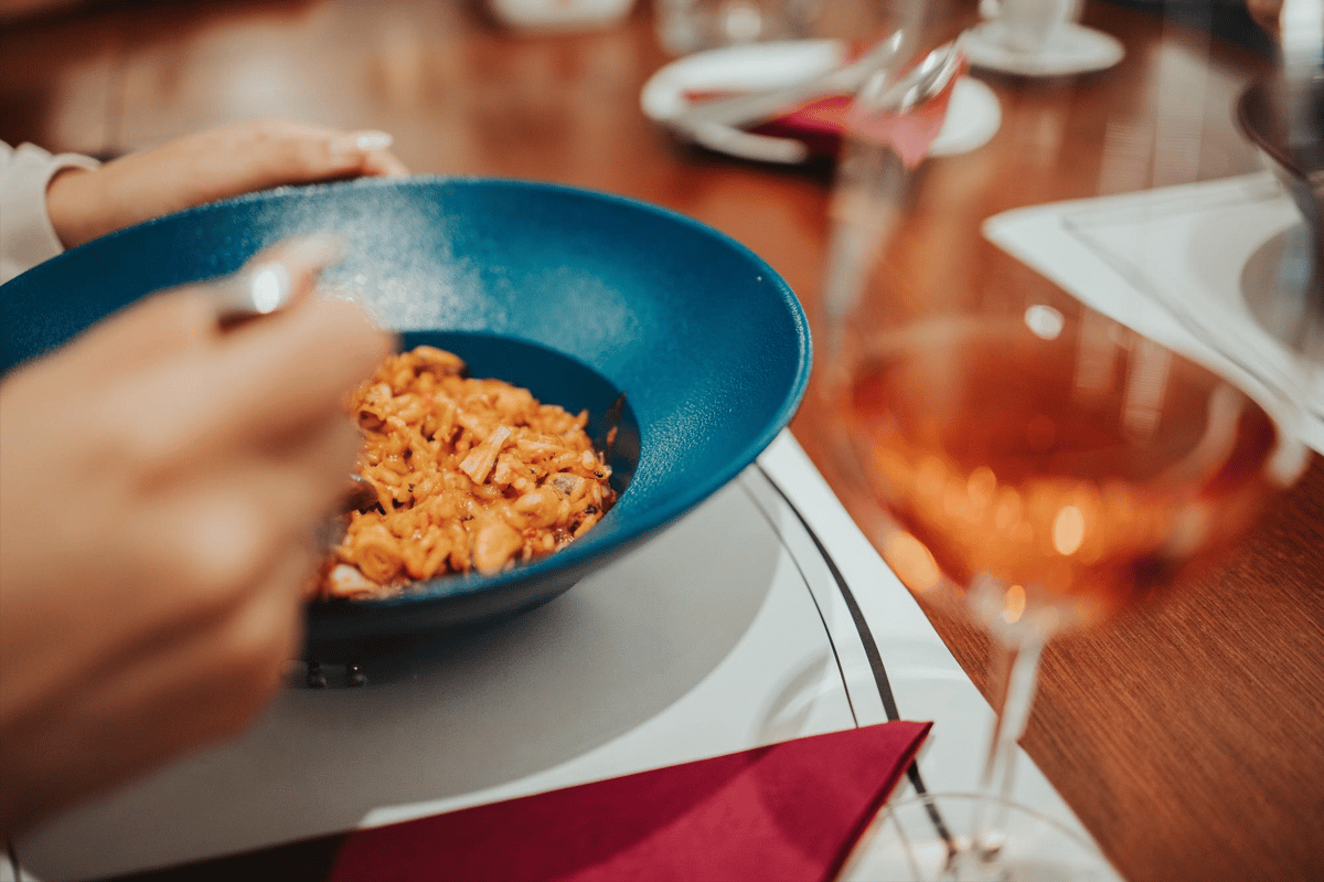 A bowl of creamy pasta paired with an elegant glass of rosé wine