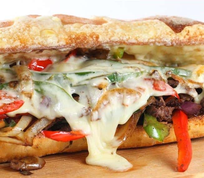 Cheese and steak sandwich with sauteed peppers and onions on a hoagie