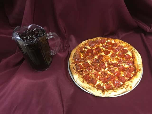 Large pepperoni pizza with a pitcher of soda
