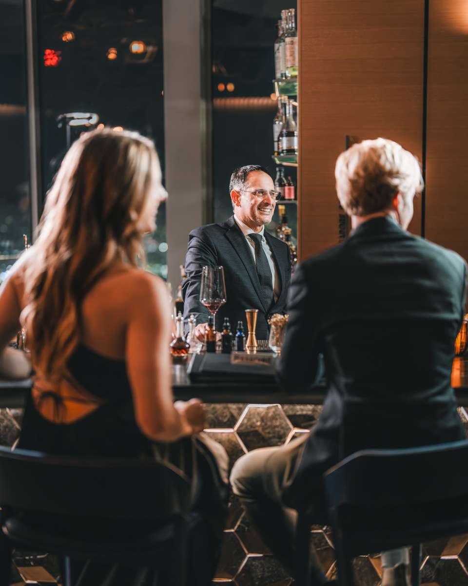 Two persons sitting next to a bar