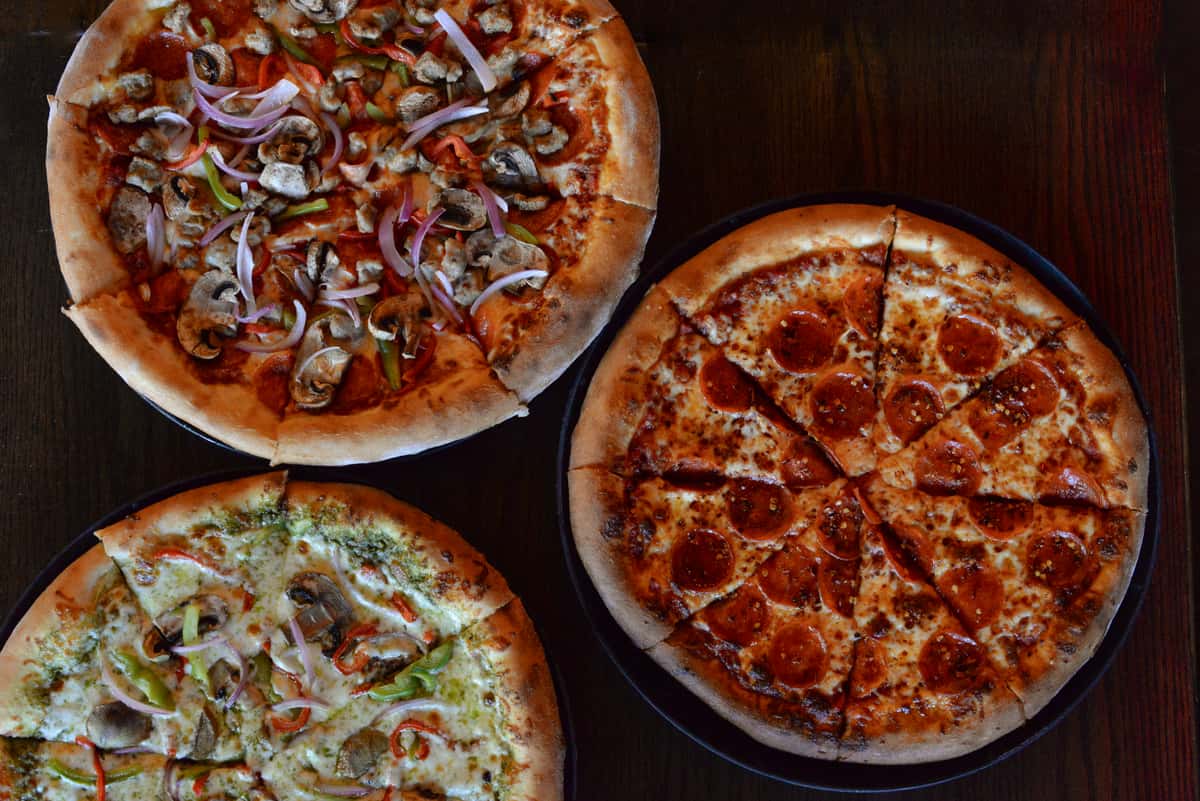 3 pizzas on a table, top down view