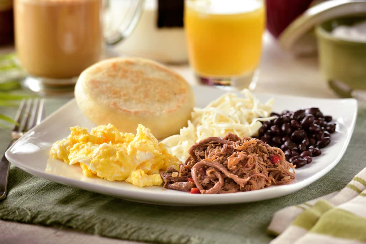 Latin Breakfast eggs, Meat, Black Beans, White Cheese and arepa with Latte