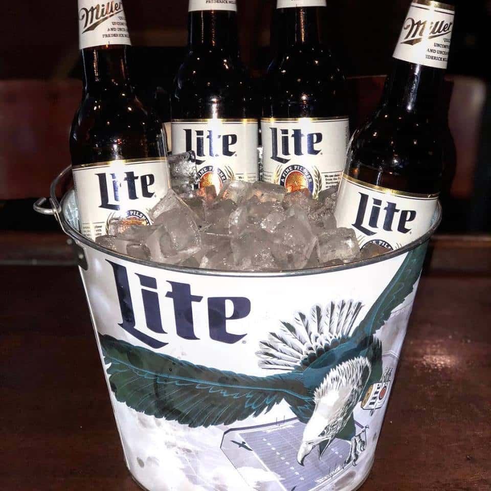 Bucket full of ice with four Miller Lites