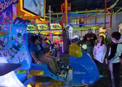 Children playing virtual reality arcade games at a birthday party at Block Party Social in Hooksett, NH, with games and party guests in the background