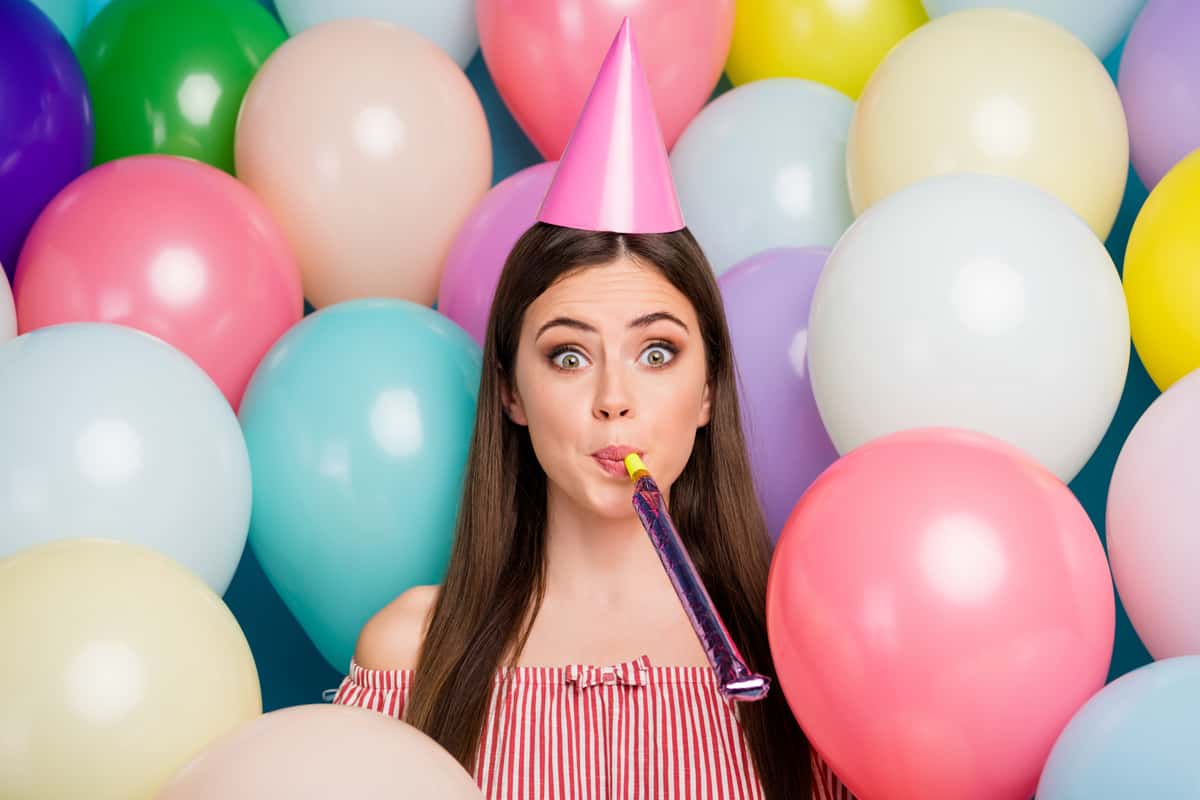 Girl with party hat and balloons