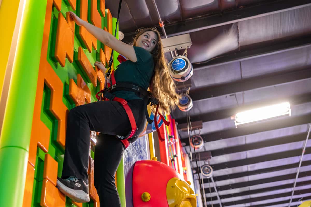 woman climbing rock climbing at Block Party Social in Hooksett, NH