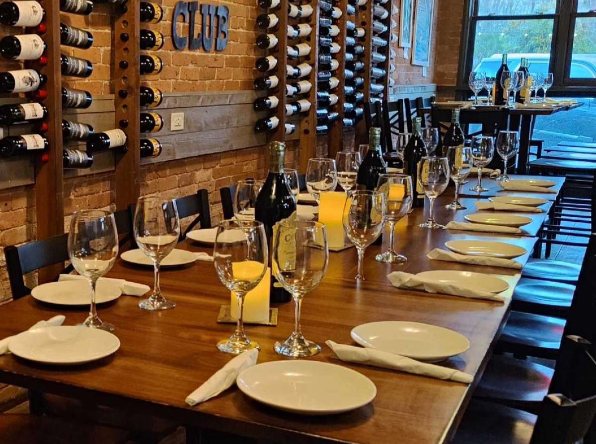 Wine dinner setup with empty plates and glasses inside wine cellar