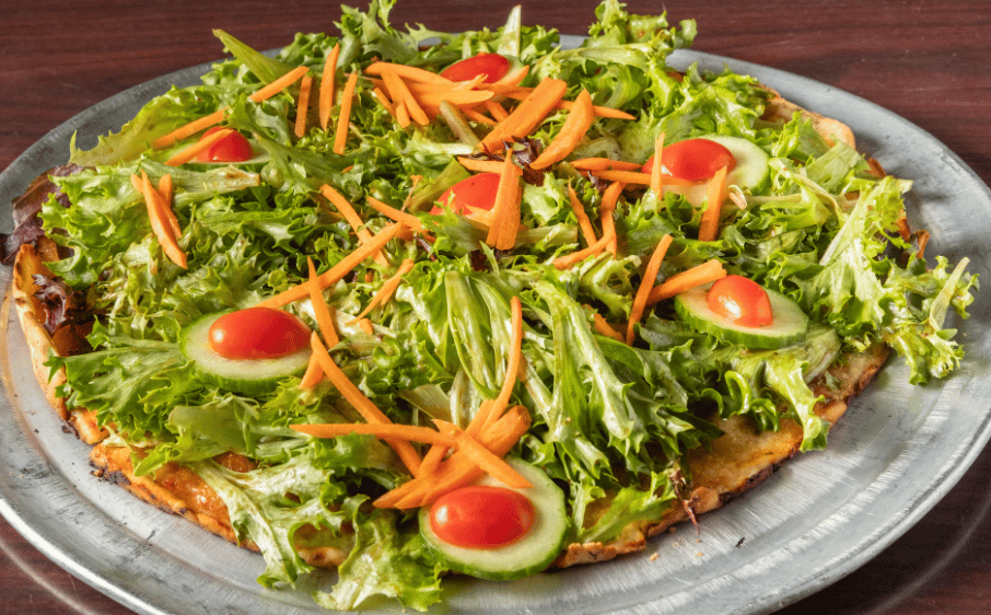 a salad pizza on a metal serving tray
