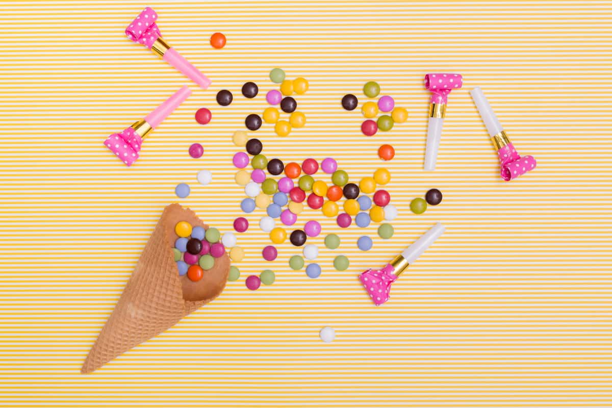 cone with sweets in yellow background