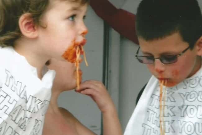 Two children eating spaghetti