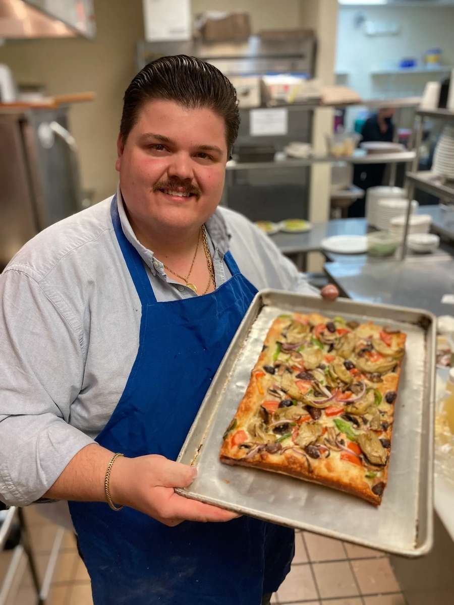 A man holding a pizza pan