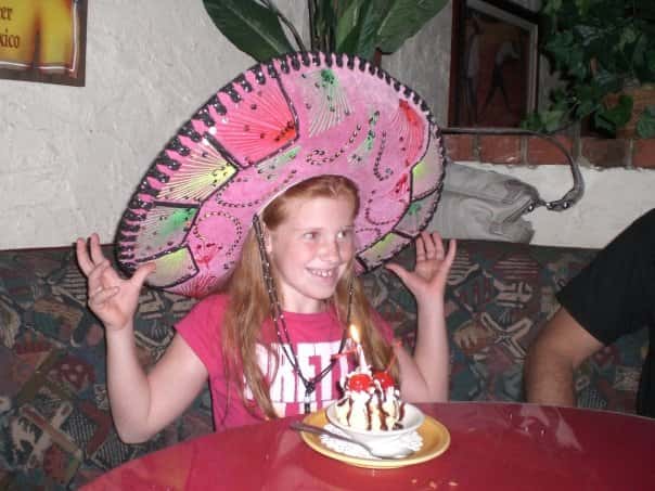 A young girl celebrating her birthday, wearing a sombrero